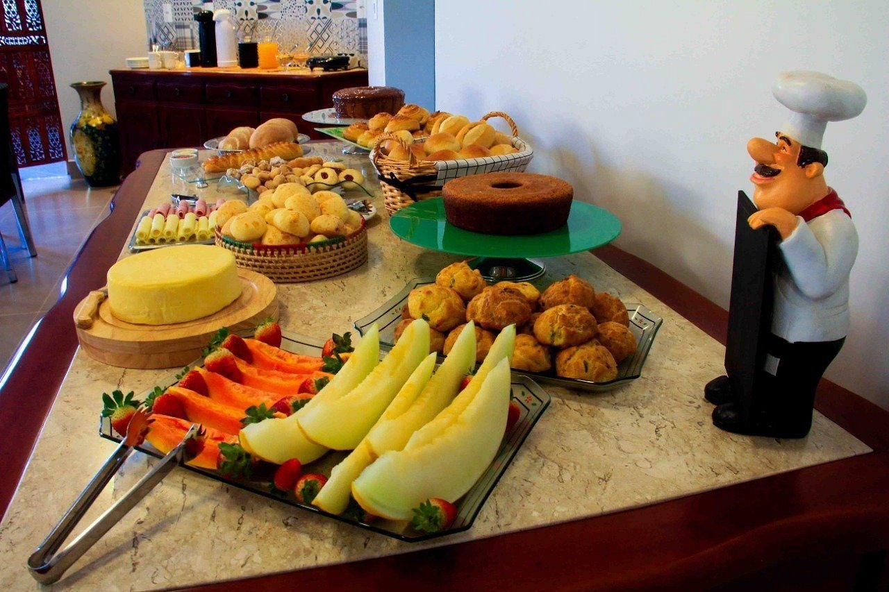 Mesa do café com frutas, bolos e quitandas