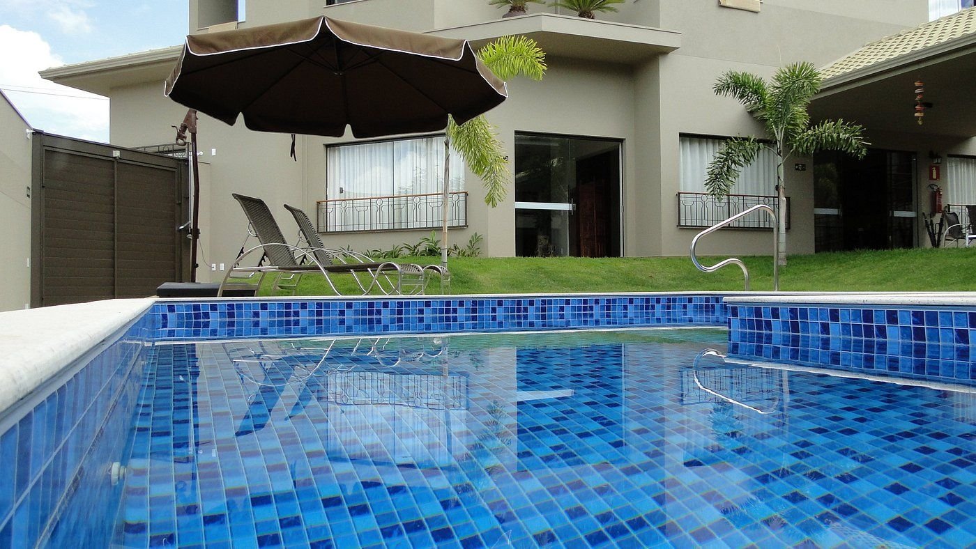 Piscina com pastilhas azuis e espreguiçadeiras